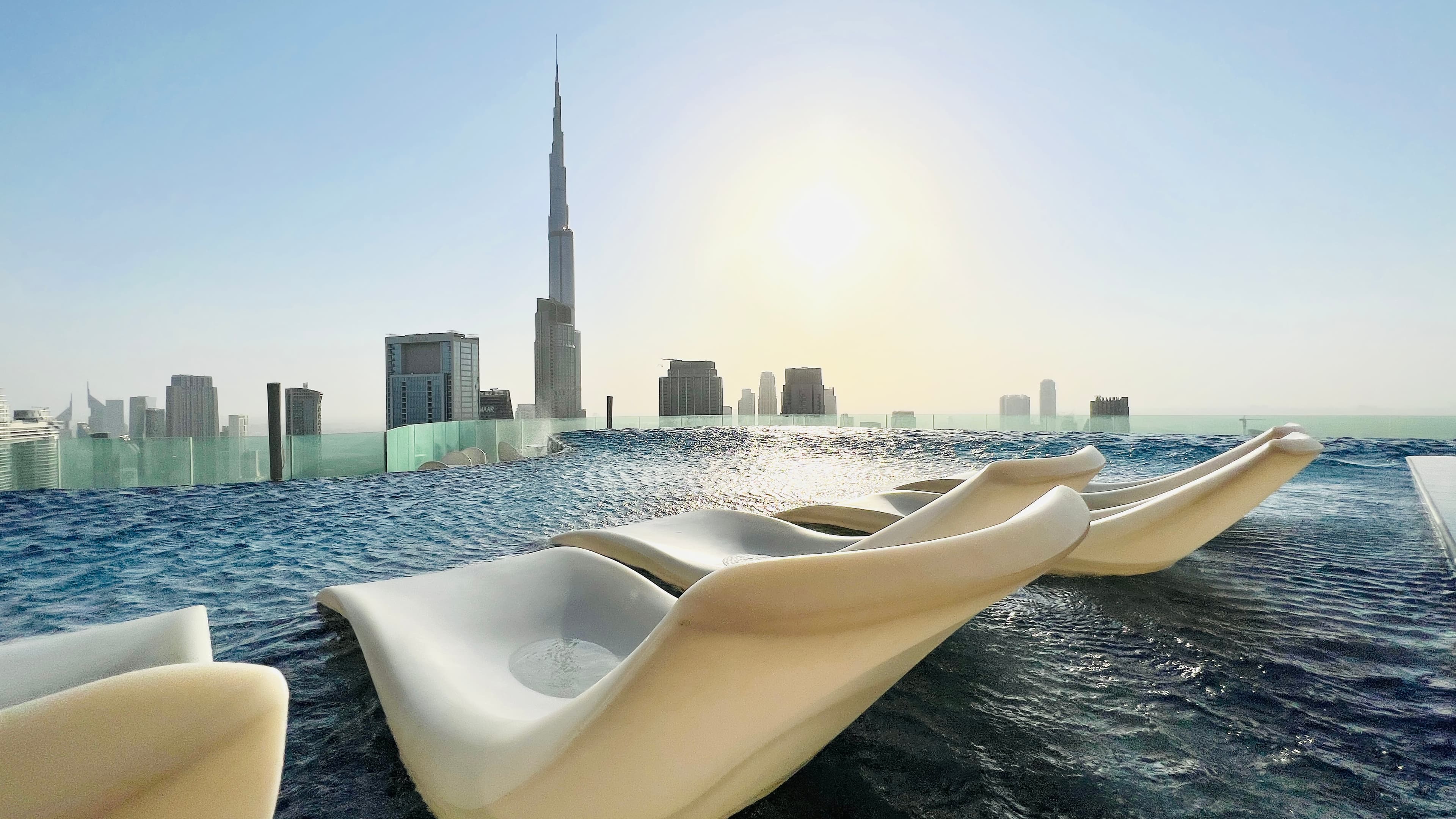 Sculptural loungers on the rooftop infinity pool with the Burj Khalifa beyond